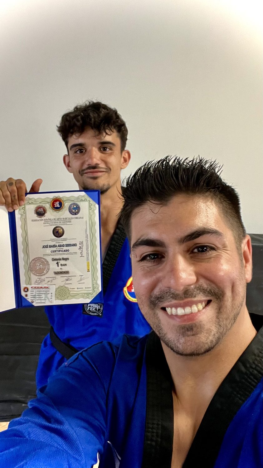 Selfie con el diploma de cinturón negro 1er Dan de un alumno